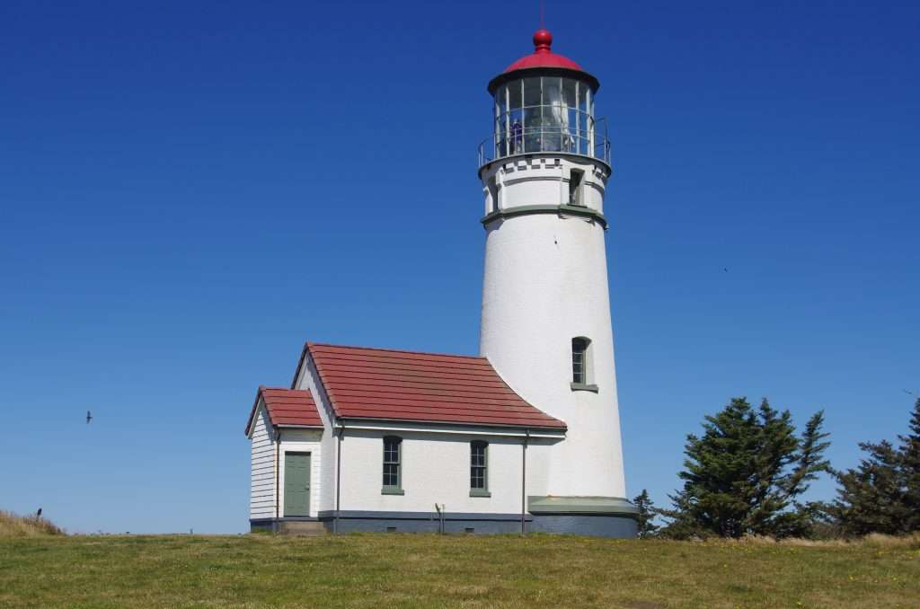 A white lighthouse with a red roof.