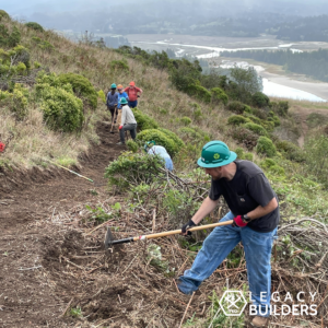 Volunteers work along a trail overlooking the Pacific Ocean.