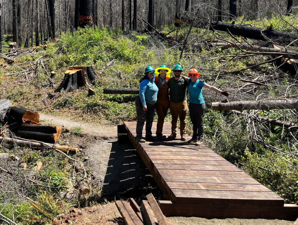 TKO volunteers pose on the newly constructed 21 foot bridge over a ravine on the Umpqua River Trail.